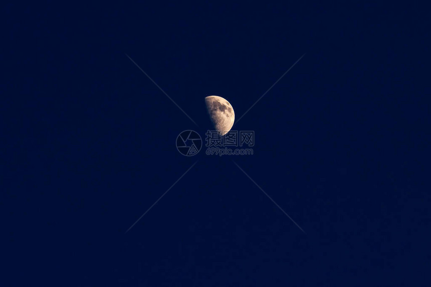 深蓝色夜空中半月相的月亮图片