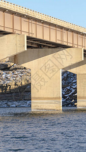 垂直框架支持蓝色湖水上梁桥的宽度的大型堤坝在背景中可以看到落基和与天图片