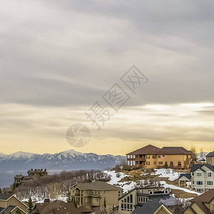 雪山上房屋的广场冬季景象与日落时云雾天相对图片