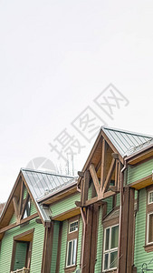 垂直架子位于有阳台和绿色水平斜坡的房屋上层楼前方图片