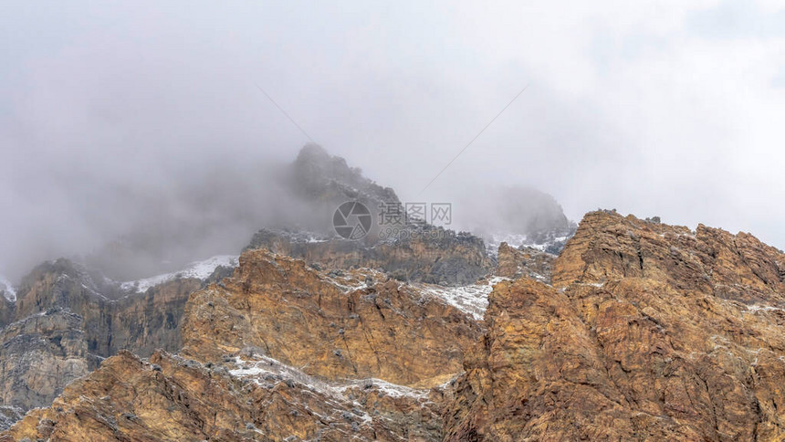 犹他州普罗沃峡谷山的崎岖和岩石坡上布满了全景云雾图片