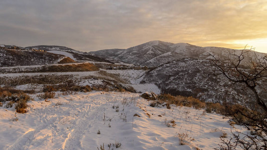 照片全景山与新鲜的白雪层反对多云的冬季天空在日落图片