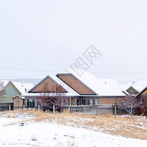 方形框架住宅社区在冬天被雪覆盖的寒冷景观上图片