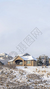 垂直框架房屋在冬季积雪覆盖的山丘上设有前山墙阳台图片