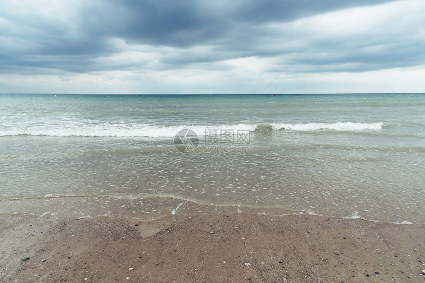 海滩有乌云和即将来临的暴风雨与恶劣天气图片