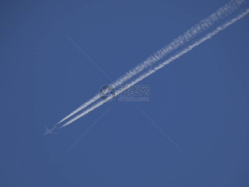 空中飞机以蓝天空背景飞行留下一条巨大的图片