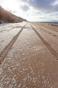 白雪覆盖的沙滩上的轮胎痕迹图片