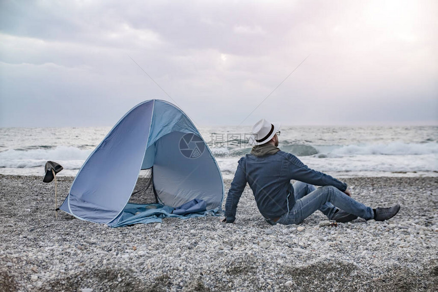 旅游者在他的露营帐篷附近对图片