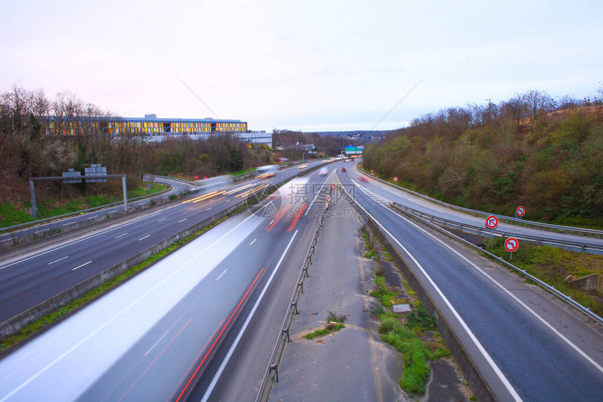 在快车道上行驶的汽车和卡车旋转高速公路上的车辆在光绘中以长时间曝光模图片