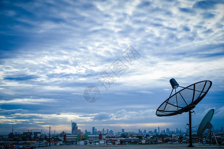 卫星天线上午在城市地区建筑物背景图片