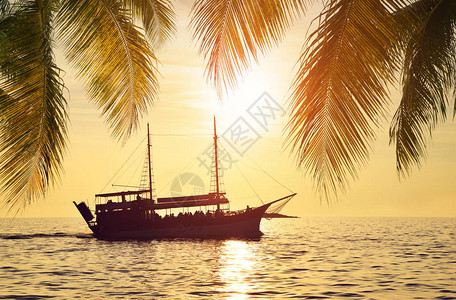 夕阳下海上一艘船的剪影图片