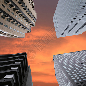 高楼从下方的视野升起在奇光天空背景上设计背景图片