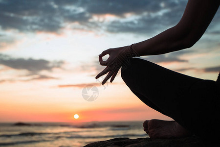 瑜伽女近身冥想者在日落图片