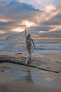 日落时沙滩上的美女图片