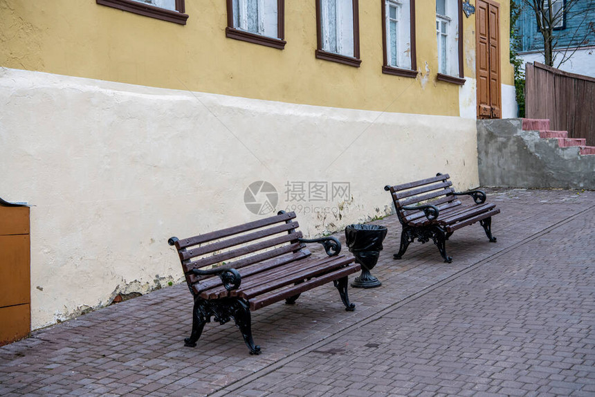 一条老街上的两条棕色长椅图片