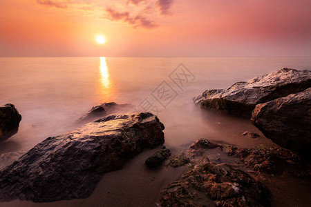 长期在日出的海景中岩石巨大图片
