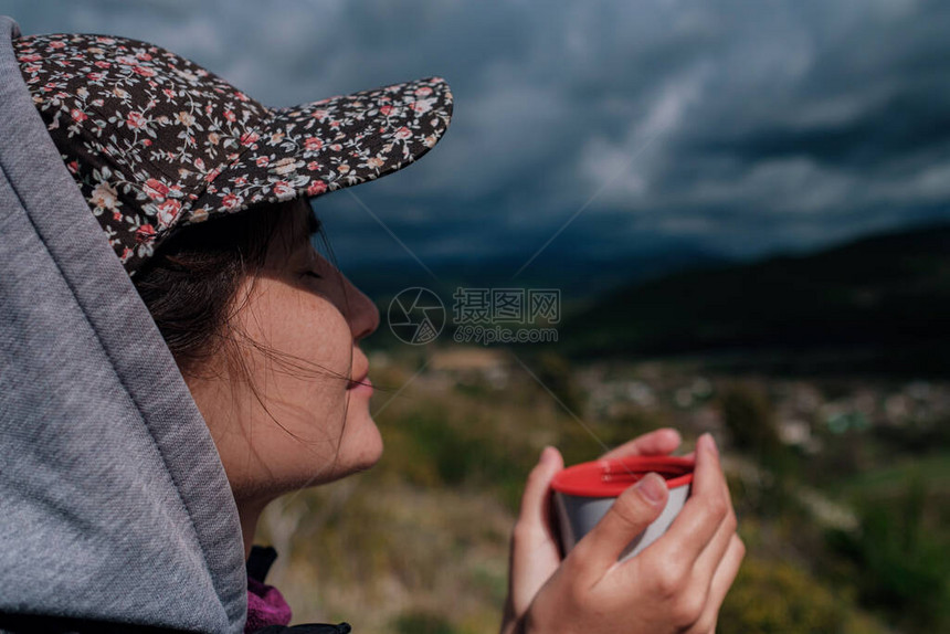 穿着帽子的旅游女孩拿着杯子图片