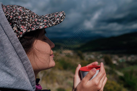 穿着帽子的旅游女孩拿着杯子图片