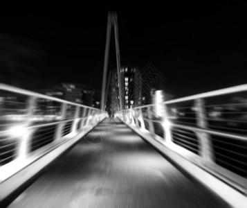 夜间城市环境中行人天桥的单色变焦模糊图像图片