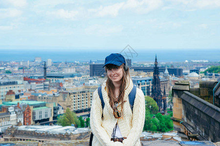带着微笑的年轻女孩在爱丁堡市外摆姿势从英国苏格兰图片
