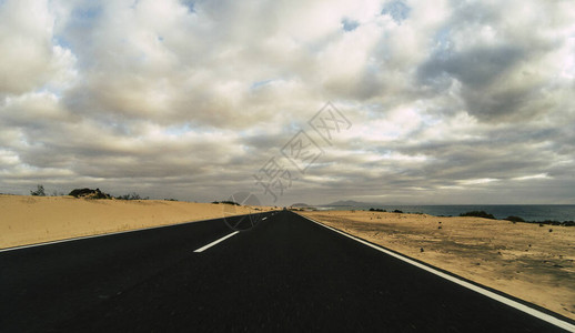 背景中的长直柏油路和蓝天的地面美景图片