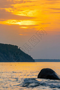 深底有悬崖水中大块巨石橙色阳光下日落时低图片