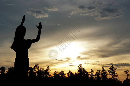 一个女人向上帝祈求祝福的剪影傍图片