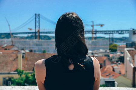 年轻女子游客在葡萄牙里斯本市著名的铁桥上欣赏美图片