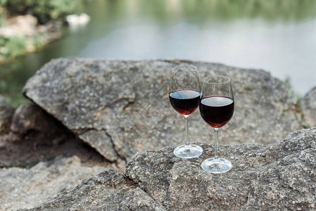 红芳香葡萄酒在石头上的红玻璃杯图片
