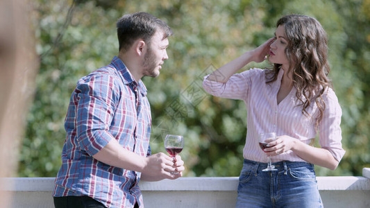 男人和女人在阳台上端着酒杯聊天视频男人和女人在派对上端着酒杯在阳图片