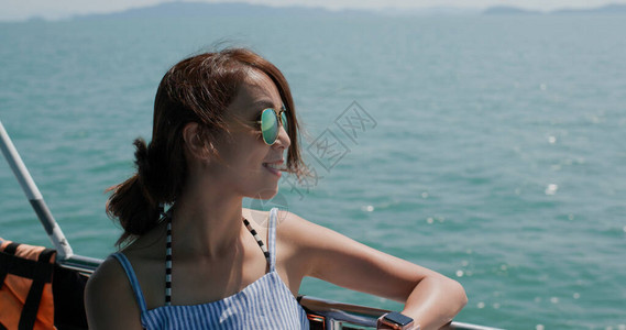 女人戴墨镜乘船看海图片