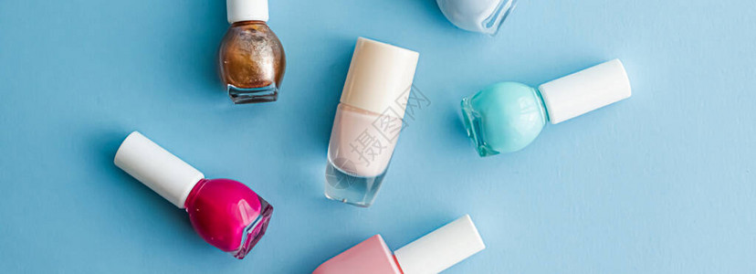 蓝色背景的彩色指甲油瓶子有机化妆品和美容产品图片