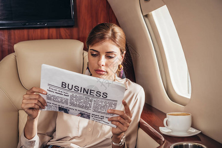 从事私人飞机上阅读报纸业的有吸引力图片