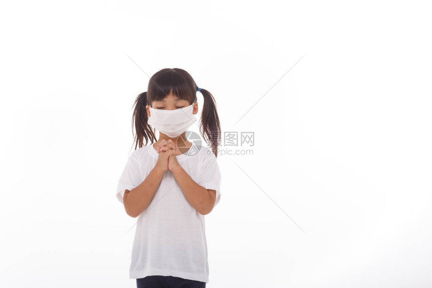 亚洲女孩戴着面具保护pm25和冠状Covid19呆在家里向上帝祈祷周日在线教堂礼拜亚洲小女孩在家祈祷社交距图片