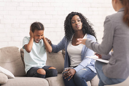 养育一个困难的孩子的概念有爱心的黑人母亲在心理学家咨询办公室安慰她背景图片