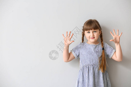 在浅色背景下使用手语的可爱聋哑女孩图片