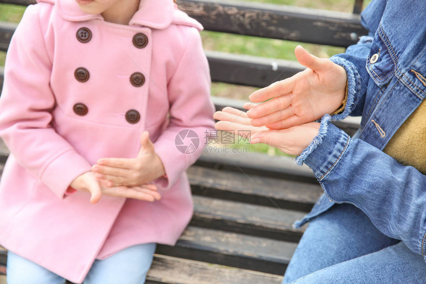 妈教聋哑女儿在户外使用手语图片