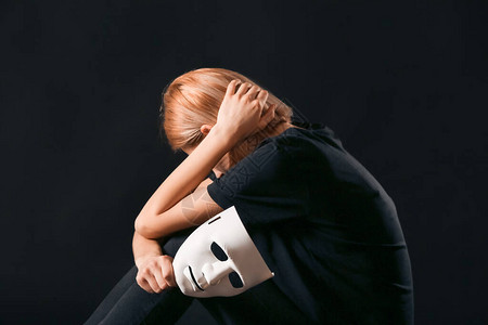 在黑暗背景下戴面具的女人抑郁症的概念图片