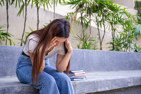 一位亚洲女学生对意外的考试分数感到失望和担忧图片