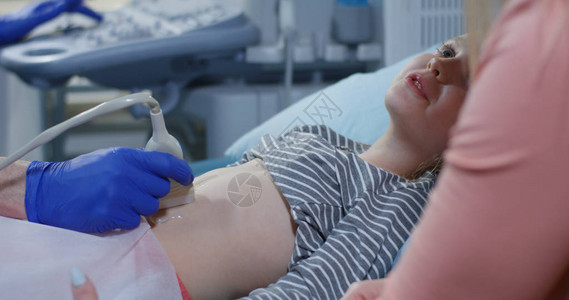 一名医生用超声波检查腹部女图片