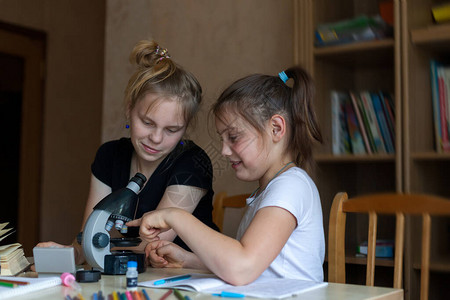 女孩用显微镜做化学作业图片