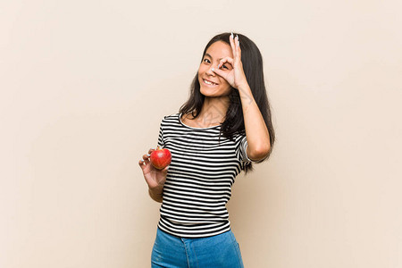 年轻的亚洲女人拿着苹果兴奋的手势保图片