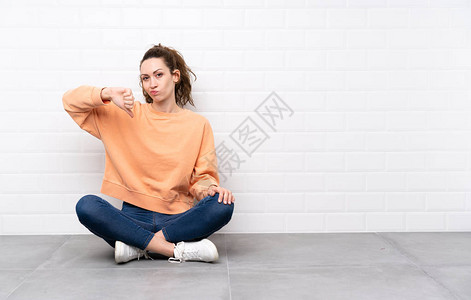 长卷发的年轻女人坐在地板图片
