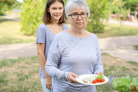 接受自愿者粮食的穷人从志愿人员获图片