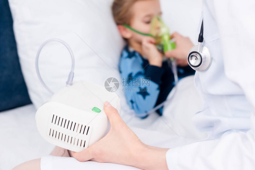 医生将压缩机吸入器放在生病孩子身边图片