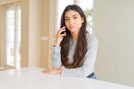在电话上说话的年轻女人与一个充满自信的谈话表现在聪明的面图片