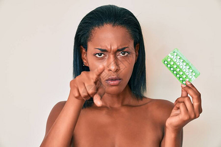 年轻的非洲裔美国妇女拿着避孕药图片