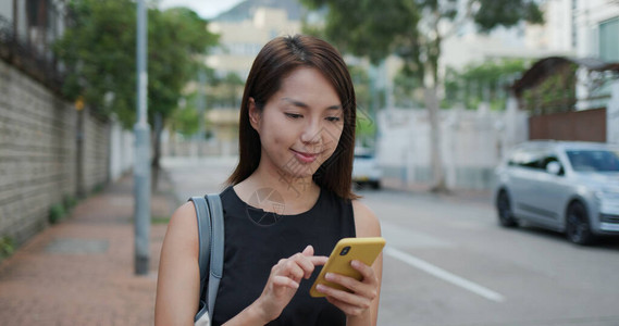 女人用手机走在街上图片