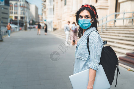 佩戴保护面罩的女学生在大学周围走来图片