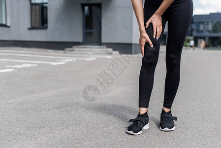 穿着黑色鞋在街上腿痛的女图片
